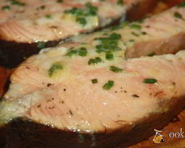 Лосось с луком на гриль-доске на мангале