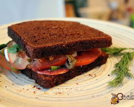 Сендвич из ржаного хлеба с салями и помидором