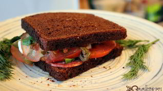 Сендвич из ржаного хлеба с салями и помидором