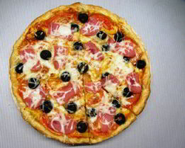 Пицца с ветчиной, помидорами и маслинами